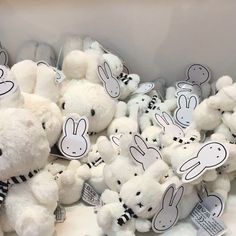 a pile of white stuffed animals sitting on top of a table next to each other