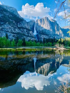 yose falls reflected in the still water of a lake surrounded by trees and mountains