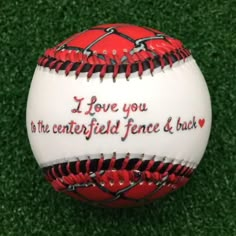 a red and white baseball with i love you to the centerfield fence and back written on it