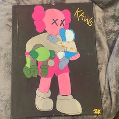 a drawing of a pink teddy bear holding a stuffed animal with the word kaws written on it