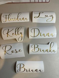 four different types of name tags hanging on a wall with the wording in gold and white