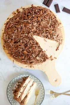 a cake with chocolate shavings on it and a slice missing from the cake