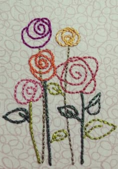 a close up of a piece of cloth with embroidery on it and flowers in the middle