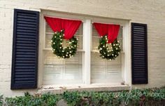 two wreaths are hanging on the windowsill