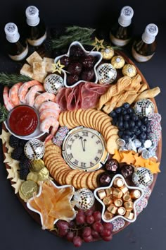 a platter filled with cheese, crackers, grapes and meats