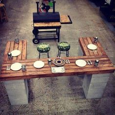 a table made out of pallet wood with plates and knives on it