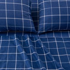 a blue and white checkered comforter set with two pillow cases on top of it