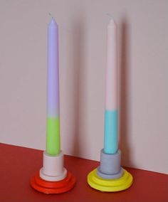 two colorful candles sitting next to each other on a table