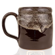 a brown and white coffee mug on a white background with reflection in the cup's bottom