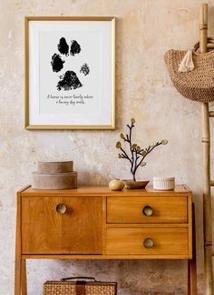 a wooden table with two baskets on it next to a wall mounted art piece and a wicker basket