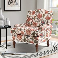 a chair sitting on top of a rug in a living room next to a window