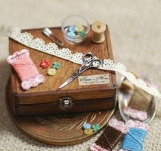 a wooden box with some sewing supplies on it