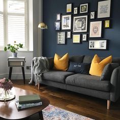 a living room filled with furniture and framed pictures on the wall above it's coffee table