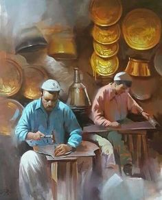 two men sitting at a table working on some type of item in front of them