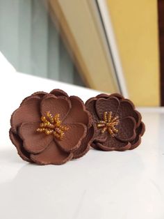 two brown flowers sitting on top of a white counter