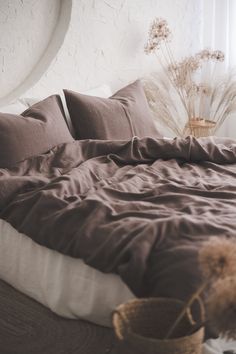 an unmade bed with brown sheets and pillows