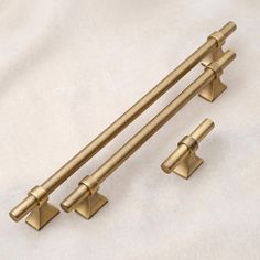 an image of two handles on a white sheet with gold colored metal hardware and knobs