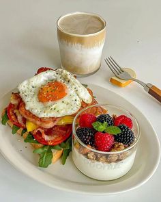 a white plate topped with food next to a cup of coffee