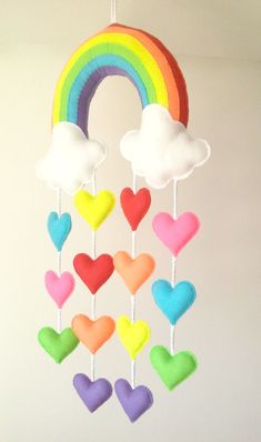 a rainbow mobile with hearts hanging from it's sides in the shape of clouds and a rainbow