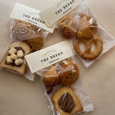 four bagels wrapped in cellophane with the bread company logo on them and labels