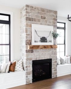 a living room with a brick fireplace and two windows