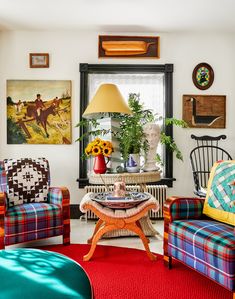 a living room filled with colorful furniture and pictures on the wall above it's windows