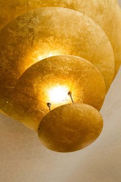 the light shines brightly in this artistic sculpture made out of gold leafy material