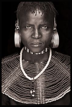 an african woman with large earrings on her head