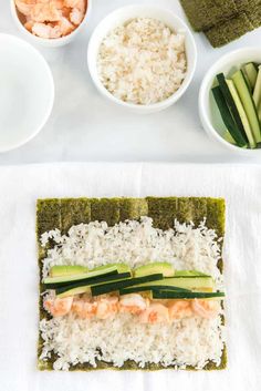 sushi with shrimp, cucumber and rice in bowls on a white table