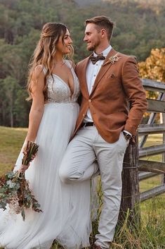 a bride and groom standing next to a fence