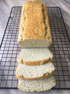 a loaf of bread sitting on top of a cooling rack next to three slices of bread