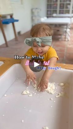 a toddler is playing in the kitchen with food on the floor and wearing a blindfold