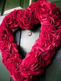 a heart shaped wreath hanging on the front door