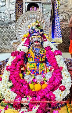 the idol is surrounded by flowers and other decorations