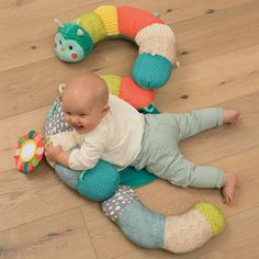 a baby is laying on the floor playing with a toy