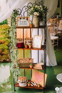 a table topped with cakes and cupcakes under a tent