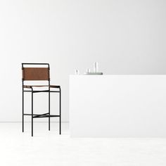 a chair sitting next to a counter in a white room