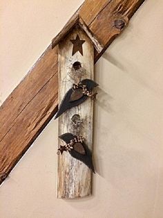 two birds are perched on the side of a wooden wall hanging from a wood beam