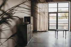 an empty room with a dresser and large window