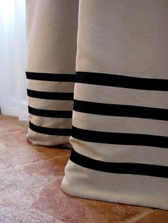 two black and white striped pillows sitting next to each other on the floor in front of a window