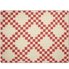 a red and white checkered quilt on a tablecloth with an area rug in the middle