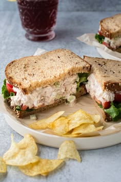 a sandwich cut in half on a plate with chips