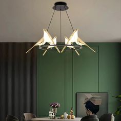 a modern chandelier hanging over a dining room table