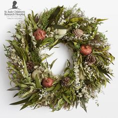 a wreath with white flowers and greenery on it is displayed against a white background