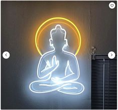 a neon buddha sitting in the middle of a room