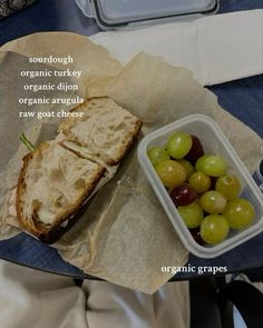 a sandwich and grapes in a plastic container