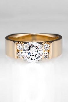 a gold ring with three diamonds on the side and a center stone in the middle