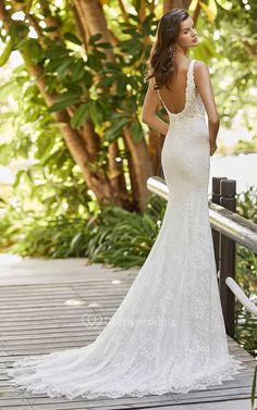 a woman in a wedding dress standing on a bridge