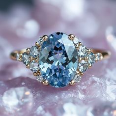 a blue and white diamond ring with three diamonds around it on top of some ice