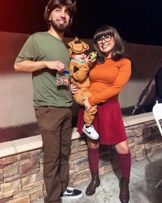 a man standing next to a woman holding a baby